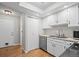 Well-lit kitchen with white cabinets, stainless steel appliances, and hardwood floors at 2748 S Kenton Ct, Aurora, CO 80014