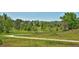 Scenic walking path with lush green grass, colorful wildflowers, and mature trees at 2748 S Kenton Ct, Aurora, CO 80014