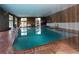 Well-lit indoor swimming pool surrounded by brick and large windows providing natural light at 2748 S Kenton Ct, Aurora, CO 80014