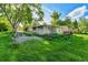 A view of the yard with a small house; landscaping is overgrown at 1930 Hoyt St, Lakewood, CO 80215