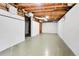 Spacious basement with painted floor, white painted walls and exposed ceiling at 1930 Hoyt St, Lakewood, CO 80215