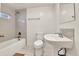 Well-lit bathroom showcasing tiled walls, a bathtub with shower, a sink, and a toilet in a functional layout at 1930 Hoyt St, Lakewood, CO 80215