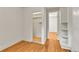 Sunlit bedroom featuring hardwood floors, white walls, and access to closet space at 1930 Hoyt St, Lakewood, CO 80215