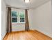 Bright bedroom with hardwood floors, white walls, and a window dressed with patterned curtains offering natural light at 1930 Hoyt St, Lakewood, CO 80215