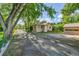 Charming tan house with mature trees, long driveway, and detached garage, offering classic appeal at 1930 Hoyt St, Lakewood, CO 80215