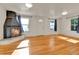 Bright living room with refinished hardwood floors and a unique corner fireplace at 1930 Hoyt St, Lakewood, CO 80215