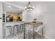 Bright dining room with modern chandelier and wood table next to an open kitchenette at 6001 S Yosemite St # H204, Greenwood Village, CO 80111