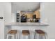 Kitchenette features a breakfast bar, track lighting, light oak cabinets, and black appliances at 6001 S Yosemite St # H204, Greenwood Village, CO 80111