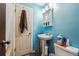Charming blue bathroom with pedestal sink, medicine cabinet, and ample lighting at 2567 Rainbow Dr # 80, Denver, CO 80229