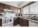 Well-lit kitchen with wooden cabinetry, a double sink, and white appliances at 2567 Rainbow Dr # 80, Denver, CO 80229