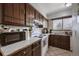 Functional kitchen with white appliances, dark wood cabinets and plenty of counter space at 2567 Rainbow Dr # 80, Denver, CO 80229