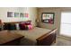 Comfortable bedroom featuring a wooden frame bed, decorative pillows, a mirror, and natural light from the window at 6490 S Dayton St # L10, Englewood, CO 80111