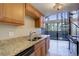 Well-lit kitchen has granite countertops, wood cabinets, and a door that leads outside at 6490 S Dayton St # L10, Englewood, CO 80111