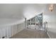Cozy loft space features neutral carpet, railing, and a window with a view of the outdoors at 6490 S Dayton St # L10, Englewood, CO 80111