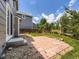 A backyard with a stone patio, landscaping gravel, green grass, and trees and shrubs along the fence at 4287 Brookwood Pl, Highlands Ranch, CO 80130
