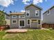 A home's backyard features a stone patio, green grass, a wood fence, and trees around the perimeter at 4287 Brookwood Pl, Highlands Ranch, CO 80130