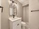 A modern bathroom features a vanity with black hardware, a lighted mirror, and marble-patterned floors at 4287 Brookwood Pl, Highlands Ranch, CO 80130