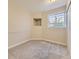 A carpeted bedroom with neutral walls and a unique niche in the wall and a window with bars on it at 4287 Brookwood Pl, Highlands Ranch, CO 80130