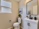 Modern powder room with a white vanity, black hardware, sleek mirror, and contemporary fixtures, offering a stylish and functional space at 4287 Brookwood Pl, Highlands Ranch, CO 80130
