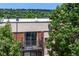 Exterior view of an apartment showcasing a private balcony, enhanced by mature trees and brick architecture at 5995 W Hampden Ave # 20B, Denver, CO 80227