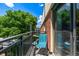 Balcony featuring a chair and side table overlooking brick apartment buildings and green trees at 5995 W Hampden Ave # 20B, Denver, CO 80227