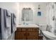 Bathroom featuring wood vanity, sink, mirror with lighting, and toilet with seashell shower curtain at 5995 W Hampden Ave # 20B, Denver, CO 80227