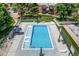 The community outdoor pool with lounge chairs provides a relaxing space, framed by green grass and lush trees at 5995 W Hampden Ave # 20B, Denver, CO 80227