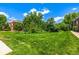 Exterior view featuring a brick apartment building behind a lawn at 5995 W Hampden Ave # 20B, Denver, CO 80227