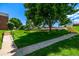 Beautiful community grounds with lush green grass, mature trees, and inviting sidewalks under a clear blue sky at 5995 W Hampden Ave # 20B, Denver, CO 80227