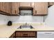 Kitchen with stainless steel sink, light wood cabinets, and white appliances at 5995 W Hampden Ave # 20B, Denver, CO 80227
