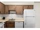 Kitchen with stainless steel sink, light wood cabinets, and white appliances at 5995 W Hampden Ave # 20B, Denver, CO 80227