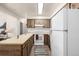Well-lit kitchen features wood cabinets and modern appliances with an island at 5995 W Hampden Ave # 20B, Denver, CO 80227