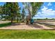 A neighborhood playground surrounded by grass and mature trees in a park-like setting at 5995 W Hampden Ave # 20B, Denver, CO 80227