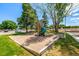 A neighborhood playground surrounded by grass and mature trees in a park-like setting at 5995 W Hampden Ave # 20B, Denver, CO 80227