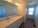 Bathroom featuring double vanity, quartz countertops, and a large mirror at 8205 Rockvale Dr, Littleton, CO 80125