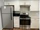 Close-up of modern kitchen appliances with white cabinets and a sleek backsplash at 2441 S Xanadu Way # A, Aurora, CO 80014