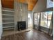 Spacious living room features a fireplace, wood-style flooring, large windows, and built-in shelving at 2441 S Xanadu Way # A, Aurora, CO 80014
