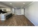 Open-concept living area with kitchen bar, wood floors, and neutral wall color provides flexible living at 2441 S Xanadu Way # A, Aurora, CO 80014