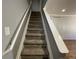 Carpeted staircase featuring white handrails, neutral walls, and a light fixture at the top landing at 2441 S Xanadu Way # A, Aurora, CO 80014