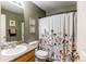Cozy bathroom with floral shower curtain, neutral walls, and a vanity with sink at 13871 Ivy St, Thornton, CO 80602