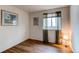 Bright bedroom with wood floors and a window offering natural light at 13871 Ivy St, Thornton, CO 80602