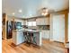 Modern kitchen features white cabinets, stainless steel appliances, and an island with counter seating at 13871 Ivy St, Thornton, CO 80602