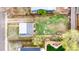 Aerial view of a fenced backyard with a green lawn, firepit, patio, and seating area at 741 Quitman St, Denver, CO 80204