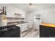 Efficient kitchen with white cabinets, dark countertops, and appliances, enhanced by gray flooring at 741 Quitman St, Denver, CO 80204