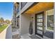 Contemporary entryway featuring a sleek black door, stylish wood accents and modern landscaping at 3880 W 13Th Ave, Denver, CO 80204