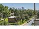 Scenic view of the Denver skyline through lush greenery and neighborhood buildings at 3880 W 13Th Ave, Denver, CO 80204