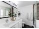 Modern bathroom with double sinks, framed mirrors, and a glass-enclosed shower with wood accent wall at 3353 Wabash St, Denver, CO 80238