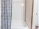 White bathtub and shower with printed blue curtain and white tile surround at 3353 Wabash St, Denver, CO 80238
