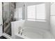 Modern bathroom featuring a glass-enclosed shower, soaking tub, and window with blinds at 3353 Wabash St, Denver, CO 80238