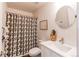 Bathroom with white sink, round mirror and black and white leaf print shower curtain at 3353 Wabash St, Denver, CO 80238